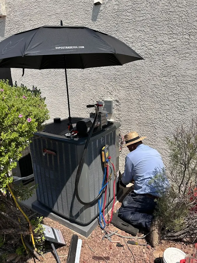 HVAC technician performing outdoor AC maintenance in Kilgore