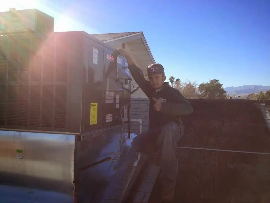 HVAC technician performing HVAC Inspection on a rooftop unit in Kilgore